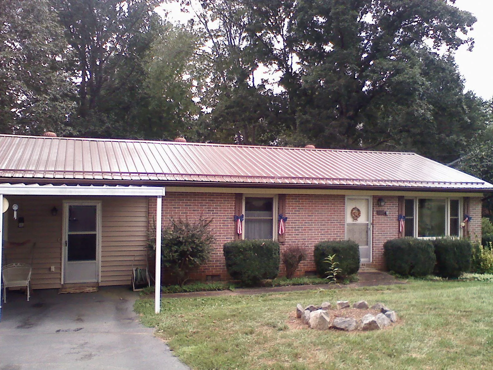 Bronze metal roof and carport on a brick ranch home — Roof Repair work by our crew in Belpre